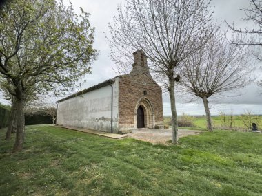 Osornillo, Palencia 'da kemerli taş kapılı küçük kırmızı tuğla şapel ve çan kulesi.