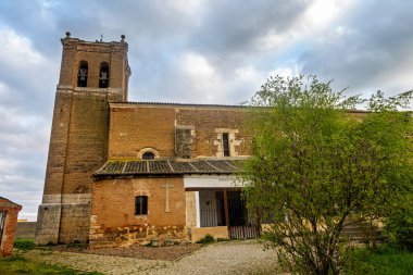 Las Cabanas de Castilla 'da tuğla çan kulesi ve taş cephesi olan eski köy kilisesi.