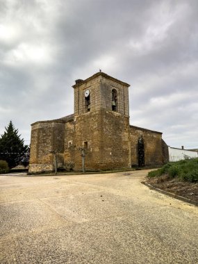 İspanya, Castilla y Leon 'da çan kulesi ve saati olan taşra kilisesi.