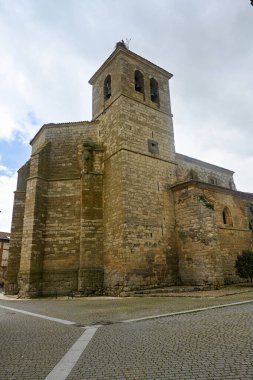 Boadilla del Camino, Palencia 'da çan kulesi ve yıpranmış duvarları olan ağır taş kilise.