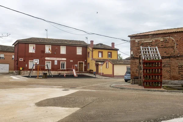 Marcilla de Campos, Palencia 'da belediye binası, oyun alanı ve geleneksel evleri olan halk meydanı.