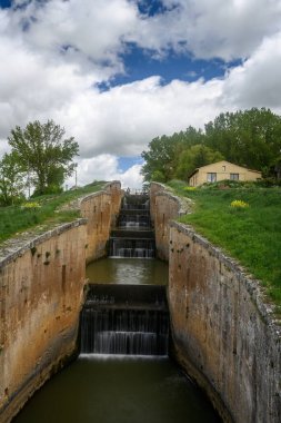 Fromista, Palencia 'daki Castilla Kanalı' nda akan su ile dört basamaklı eski bir taş kilit..