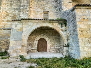 Palacios del Alcor, Palencia 'da yeşil bir yamaçta taş çan kulesi olan tarihi kırsal kilise.