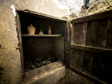 Cordovilla Real 'deki bir şarap mahzeninde killi sürahi, şişeler ve aletlerle taşralı peynir deposu.
