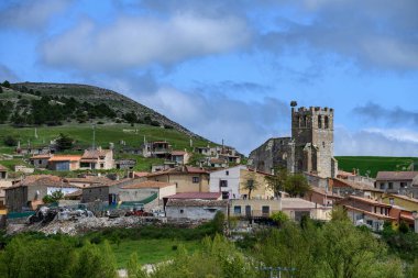 Çatı ve yeşil tepelerle çevrili, güçlendirilmiş kulesi ve leylek yuvası olan eski taş kilise.