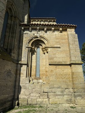 Merkezi kulesi ve maymunları olan tarihi taş manastırı Palencia 'da ağaçların ve ekilmiş tarlaların arasına yerleştirilmiş.