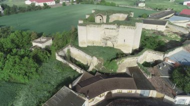 Kırsal alan ve modern rüzgar türbinleri arasında yıkık bir ortaçağ şatosunun insansız hava aracı görüntüsü