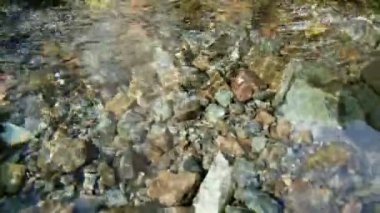 Küçük bir dağ nehrinde akan temiz suya yaklaşın, yavaş çekim ve sığ alan derinliği.