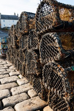 Lobster traps on cobble stones clipart