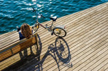 Woman with bicycle on  wooden promenade