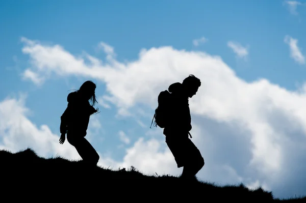 Άνδρας και γυναίκα που περπατά κάτω από έναν λόφο — Φωτογραφία Αρχείου