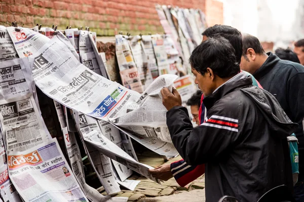 Men reading newspapers for sale — Stockfoto