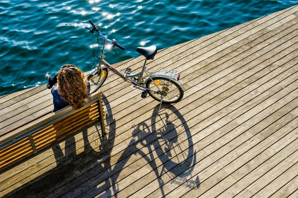 Woman with bicycle on  wooden promenade — Zdjęcie stockowe