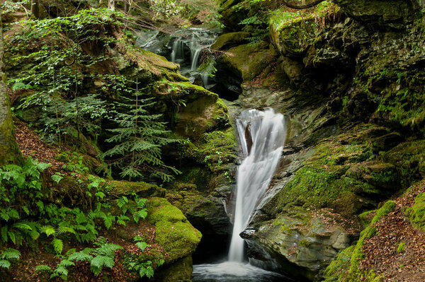 Waterfall between green stones