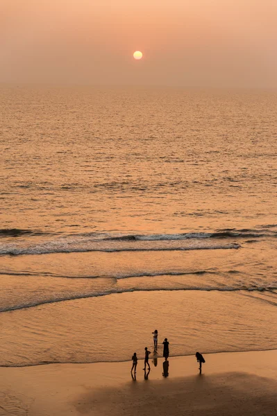 Pessoas andando ao longo da praia — Fotografia de Stock
