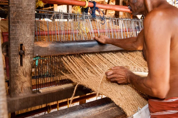 Man working with hand  operated coir loom