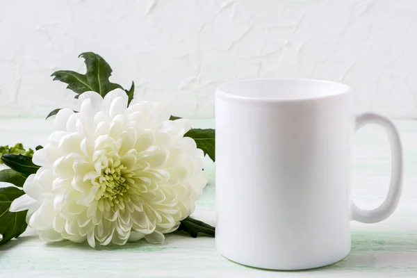 White coffee mug mockup with white chrysanthemum. Empty mug mock up for design presentation.