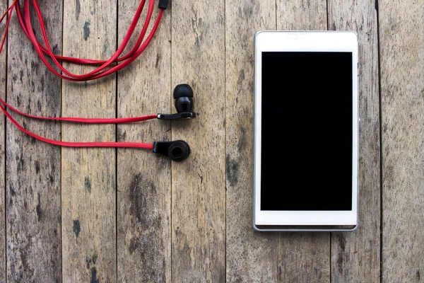 Mobiltelefon och hörlurar på trä bakgrund, lyssnande set — Stockfoto