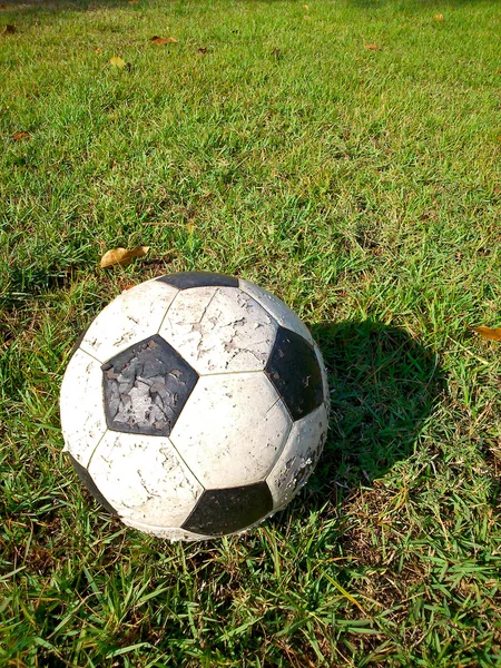 Futebol velho no campo de grama pela manhã — Fotografia de Stock