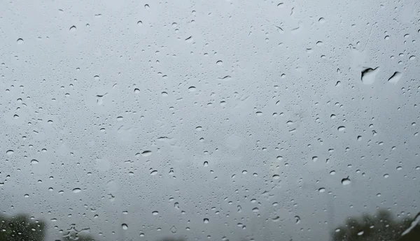 Gotas de lluvia en el vidrio del coche frontal, fondo de la naturaleza Imagen de stock