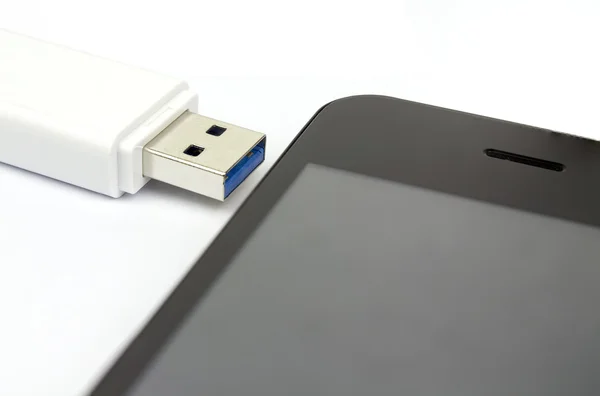 USB flash drive 3.0 και έξυπνο τηλέφωνο σε άσπρο φόντο, έννοια κοινής χρήσης δεδομένων — Φωτογραφία Αρχείου