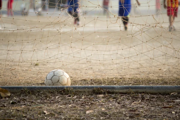 Futebol velho no objetivo, as crianças estão jogando — Fotografia de Stock