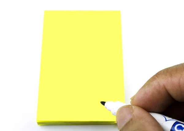 Humano está escrevendo algum texto em uma nota de papel amarelo — Fotografia de Stock