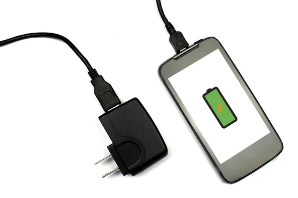 Мобильный телефон и зарядное устройство на белом фоне, изолированные — стоковое фото