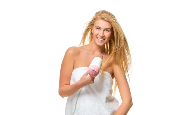 Young woman in towel dries hair a hairdryer — Stock Photo, Image