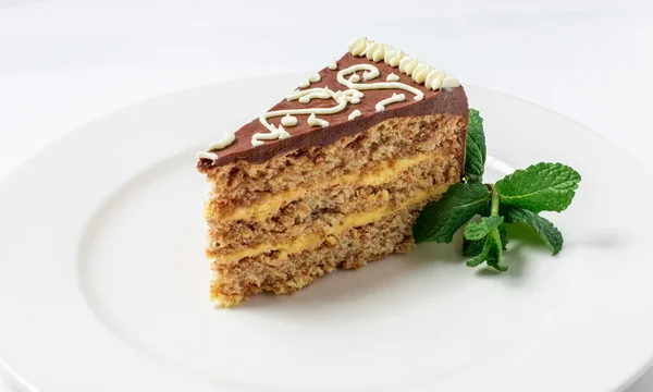 Piece of Kiev cake with chocolate cream and decorated mint