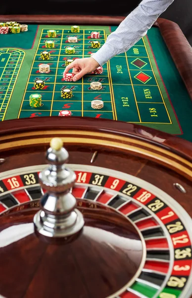 Ρουλέτα και σωρούς των τυχερών παιχνιδιών μάρκες σε ένα πράσινο τραπέζι. — Φωτογραφία Αρχείου
