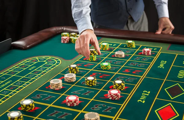 Foto van een groene tafel en weddenschappen met chips. — Stockfoto