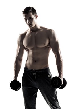 Strong athletic man showing muscular body with dumbbells