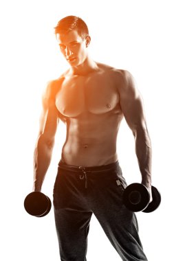 Strong athletic man showing muscular body with dumbbells