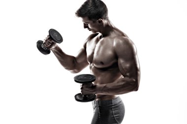 Athletic man showing muscular body and doing exercises with dumbbells