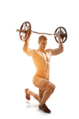 Muscular man standing on knee, holding barbell over his head