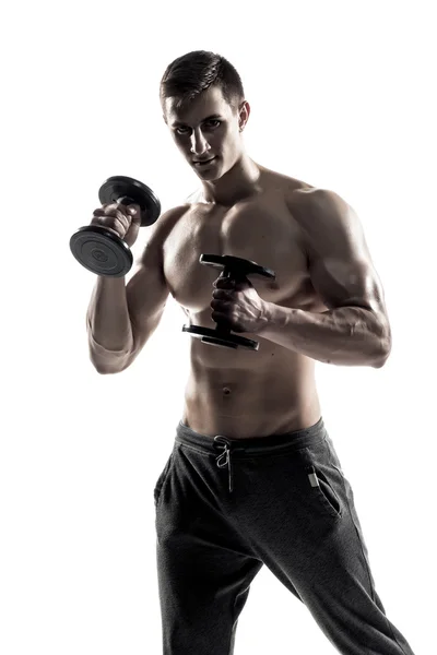 Athletic man showing muscular body and doing exercises with dumbbells — Stok fotoğraf