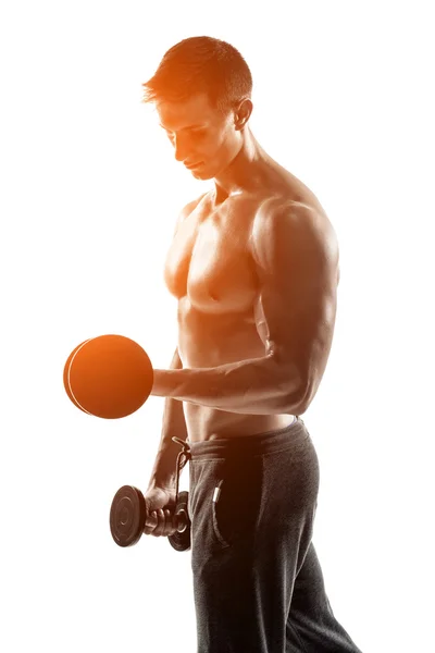 Athletic man showing muscular body and doing exercises with dumbbells — Stok fotoğraf