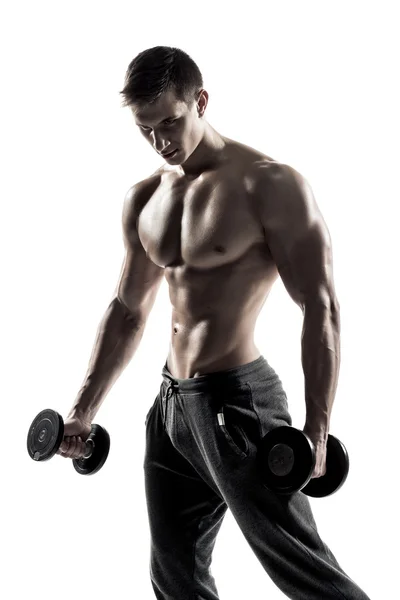 Сильный спортсмен показывает мускулистое тело с гантелями — стоковое фото