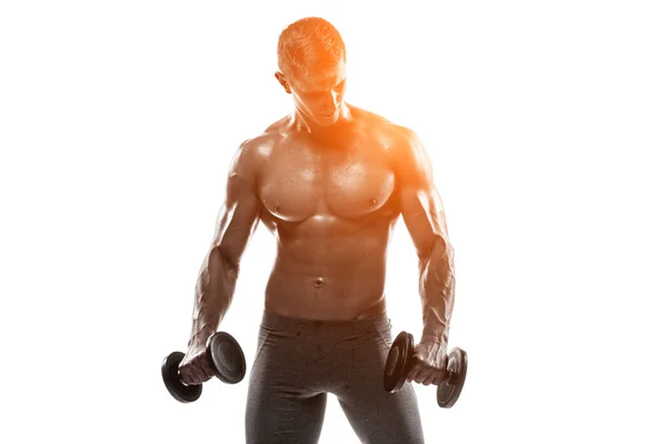 Hombre atlético mostrando el cuerpo muscular y haciendo ejercicios con pesas —  Fotos de Stock