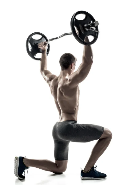 Fitness man standing on knee and holding barbell, rear view — ストック写真