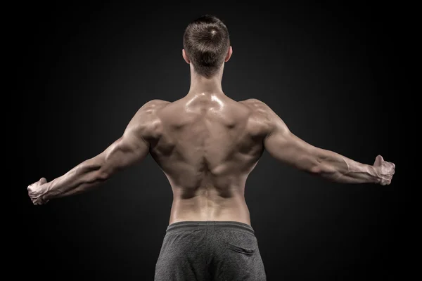 Visão traseira do homem musculoso com os braços estendidos — Fotografia de Stock