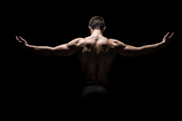 Rear view of muscular man with his arms stretched out