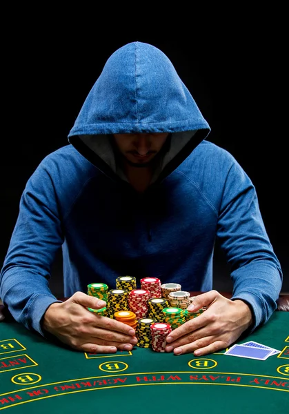 Poker player taking poker chips after winning