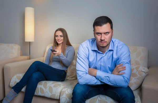 Portrait of couple sitting on sofa watching television. — Stock Fotó
