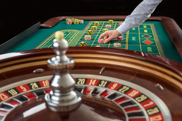 Roulette en stapels chips op een groene tafel gokken. — Stockfoto