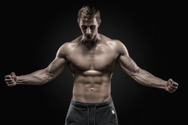 Stunning muscular man showing perfect abs, shoulders, biceps, triceps, chest