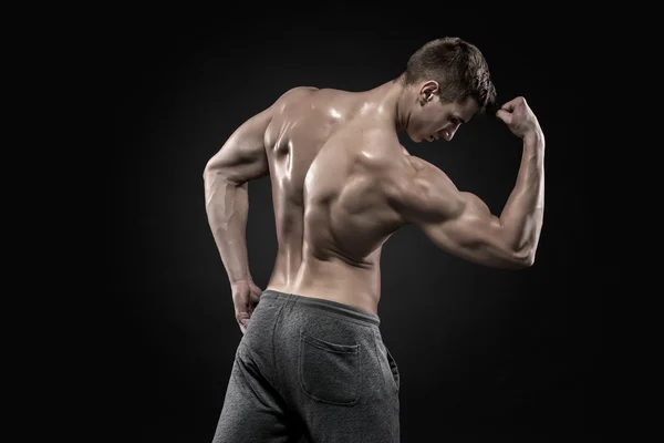 Uomo muscoloso sano su mostrando bicipiti perfetti, tricipiti, vista posteriore — Foto Stock