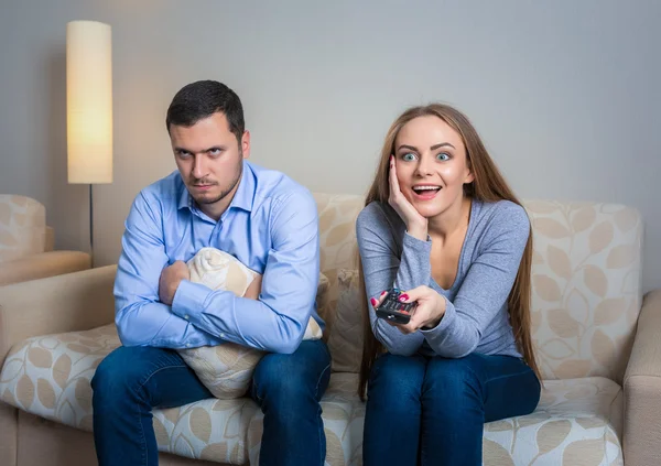 Portrait of couple sitting on sofa watching television. — Stock Fotó