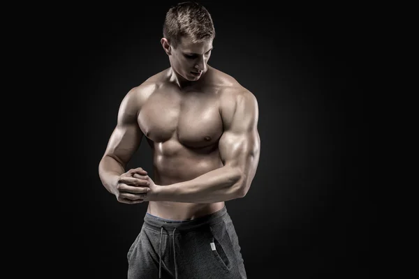 Приголомшливий м'язистий чоловік показує ідеальні плечі, біцепси, трицепси, груди — стокове фото